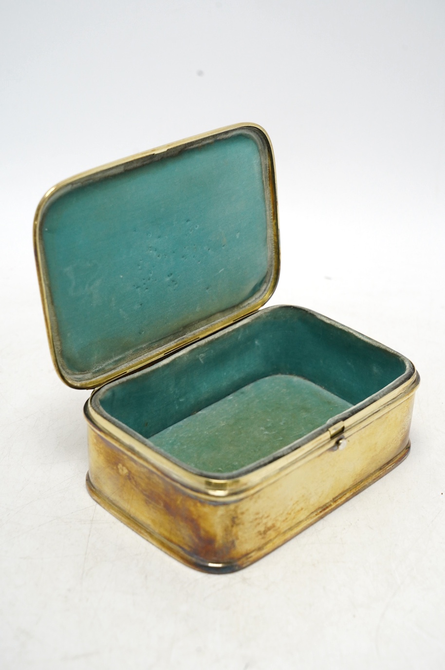 An American sterling trinket box with hinged cover and foliate scroll decoration, engraved with monogram, 13.4cm, gross weight 300 grams. Condition - fair